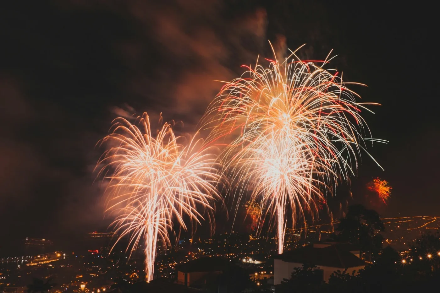 Fireworks bursting over the lights of Funchal on New Year’s Eve, photographed from the hillside district of Livramento