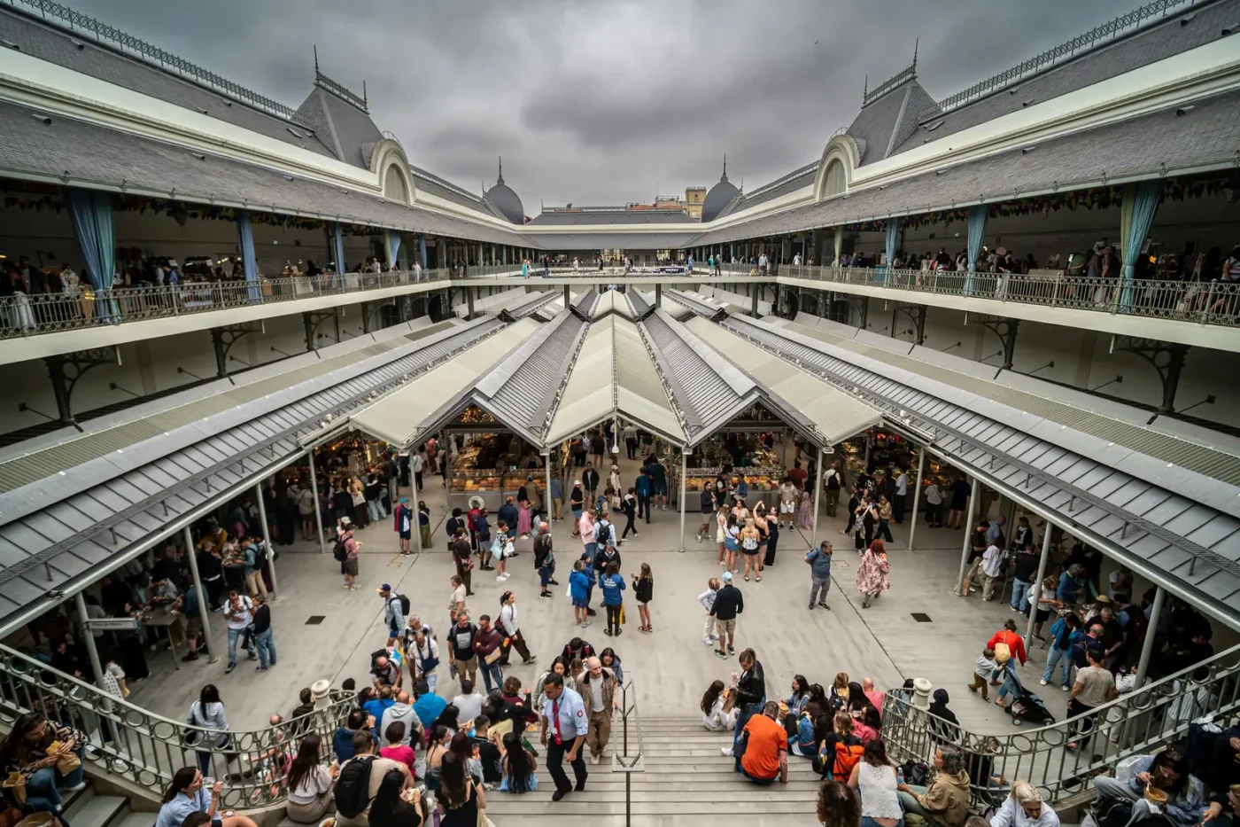 Inside Porto’s Mercado do Bolhão, seen from the upper gallery: shoppers in the central courtyard under covered walkways